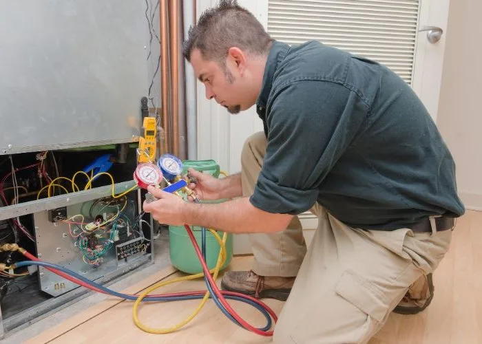 Technician performing maintenance on an HVAC unit for 24/7 Emergency HVAC Services in New Caney, TX by The Chill Brothers.