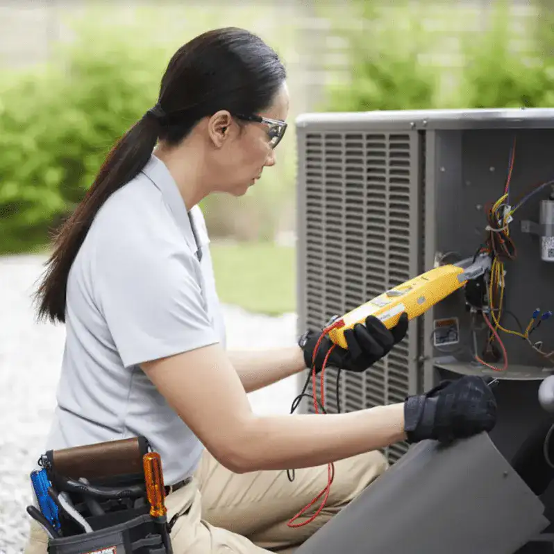 A woman works on an air conditioning unit, showcasing The Chill Brothers' expertise in AC repair and maintenance in Houston, TX.