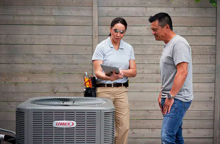 Two men beside an HVAC unit, representing air conditioning repair services by The Chill Brothers.