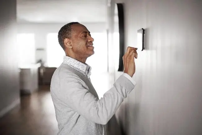 A man stands in a room with a white wall, representing a calm and minimalist environment for The Chill Brothers.