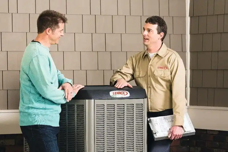 Two men conversing next to an air conditioner, focusing on The Chill Maintenance Plan for enhanced climate control.